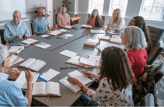 Group of people sitting around a table having a home group discussion
